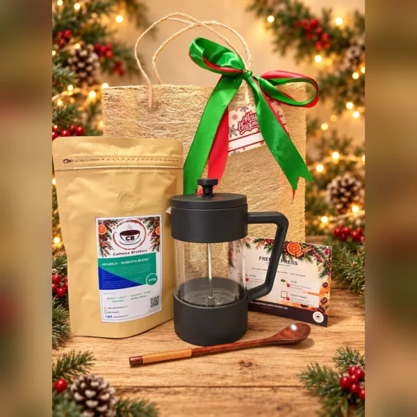 French press, Arabica-Robusta Blend coffee pouch, brewing guide card and wooden spoon with an abaca gift bag on a Christmas table